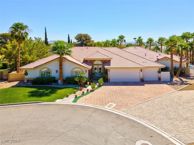 view of front of home with a garage, a front yard, and french doors