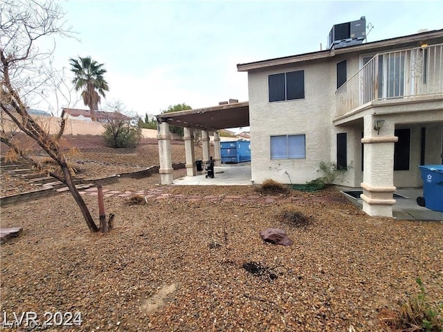 rear view of house with central air condition unit and a patio area