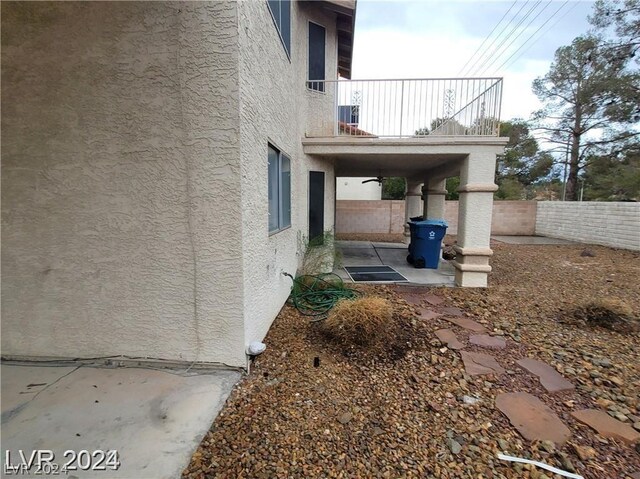 view of property exterior with a patio and a balcony