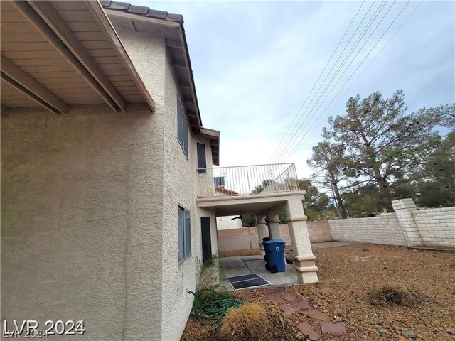 view of property exterior featuring a balcony and a patio area