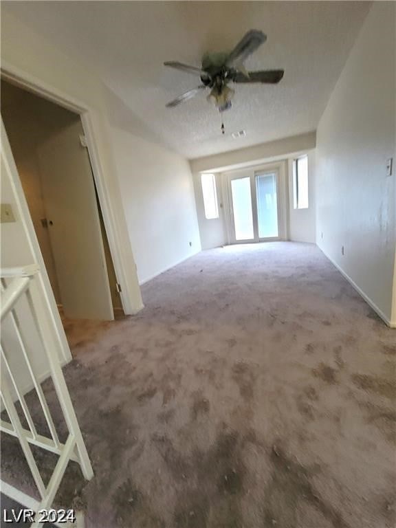 empty room featuring carpet floors and ceiling fan