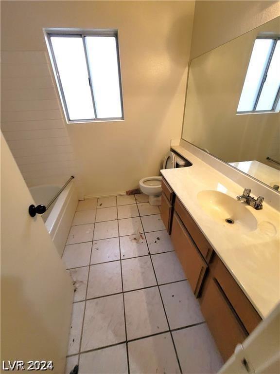 full bathroom with tile patterned flooring, toilet, vanity, and plenty of natural light