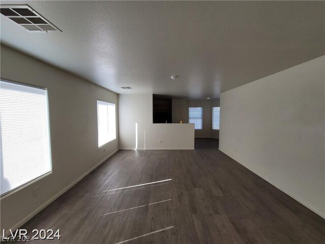 unfurnished living room with a textured ceiling and hardwood / wood-style flooring