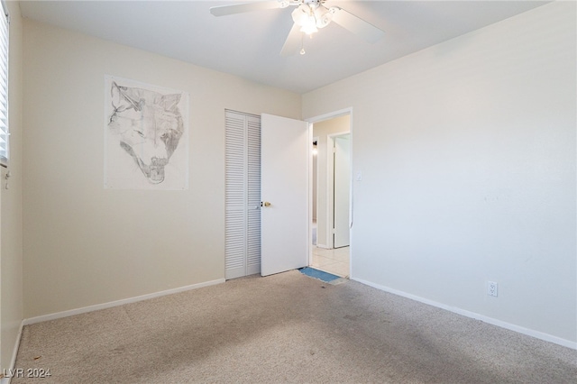 carpeted spare room with ceiling fan