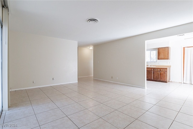 empty room featuring sink and light tile patterned floors