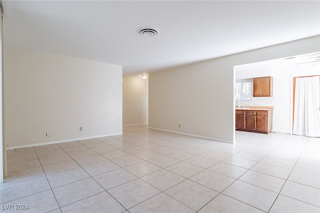 tiled empty room featuring ceiling fan