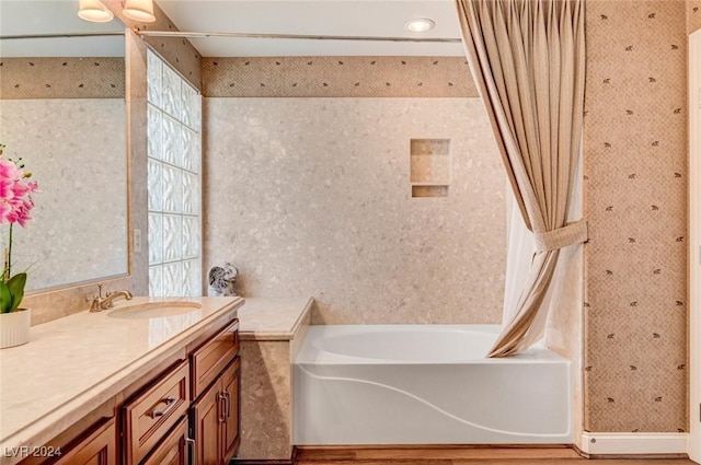 bathroom featuring vanity, a shower with curtain, a tub to relax in, wood finished floors, and wallpapered walls