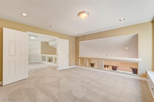 empty room featuring recessed lighting, light colored carpet, and baseboards