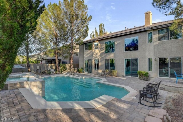 view of swimming pool featuring an in ground hot tub and a patio area