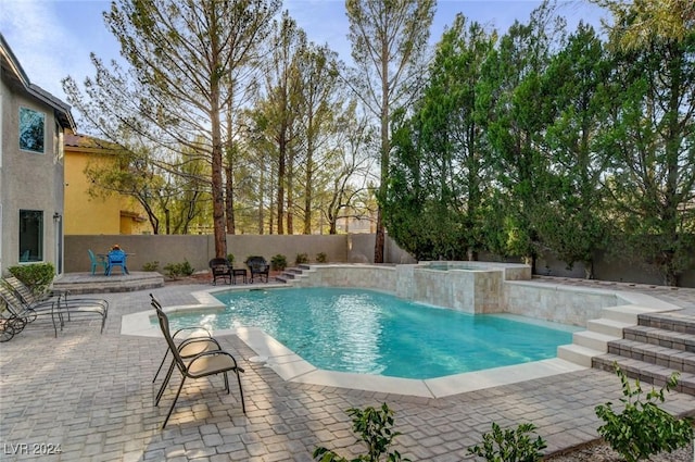 view of swimming pool featuring a patio, pool water feature, and an in ground hot tub