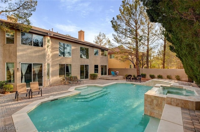 view of swimming pool featuring a patio and an in ground hot tub