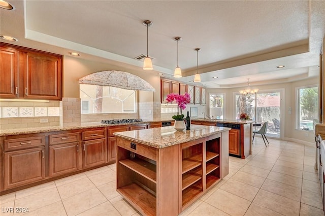 kitchen with backsplash, a tray ceiling, a peninsula, brown cabinetry, and open shelves