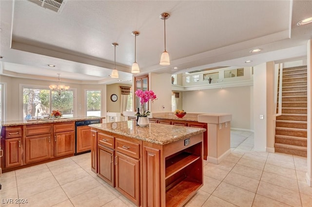 kitchen with a sink, a tray ceiling, a center island, brown cabinetry, and dishwasher