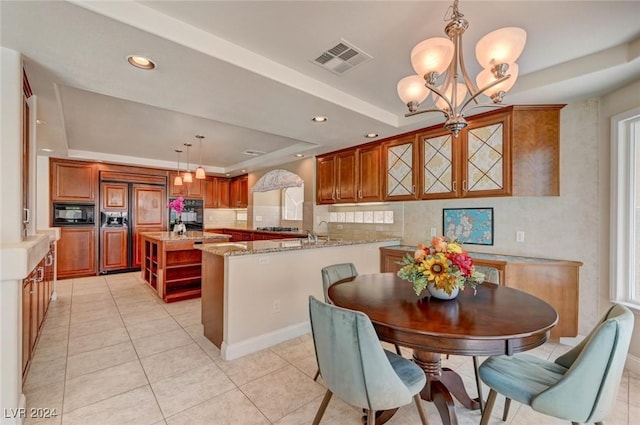 tiled dining space featuring an inviting chandelier and a tray ceiling