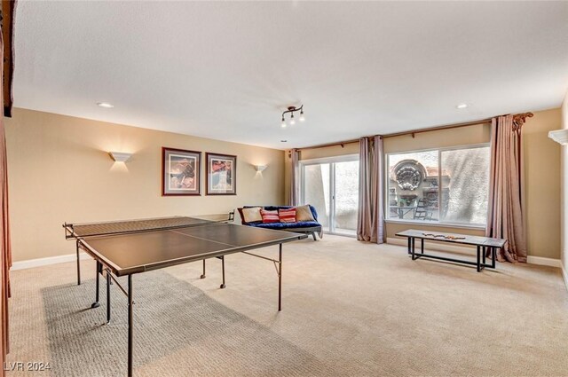 recreation room featuring light colored carpet