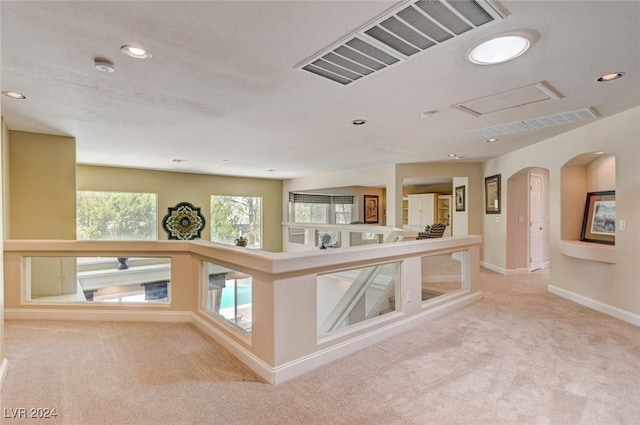 hallway with visible vents, baseboards, carpet floors, recessed lighting, and arched walkways