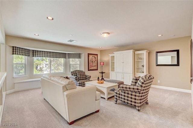 living room featuring recessed lighting, light colored carpet, visible vents, and baseboards