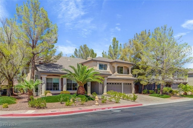 view of front of home with stucco siding, an attached garage, and driveway