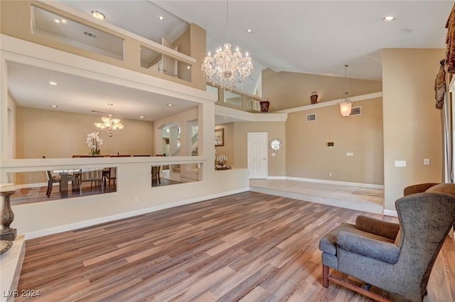 living room featuring high vaulted ceiling, hardwood / wood-style flooring, and a notable chandelier