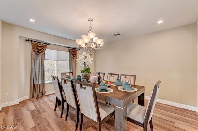 dining area featuring light wood-type flooring and a notable chandelier