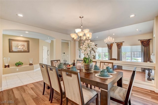 dining area with a notable chandelier and light hardwood / wood-style flooring