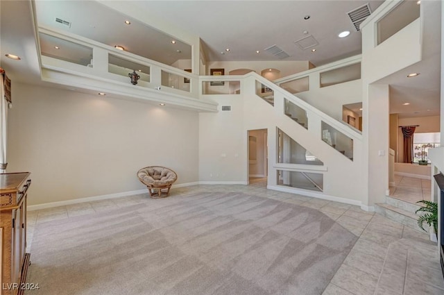 unfurnished living room featuring recessed lighting, visible vents, carpet floors, and stairway