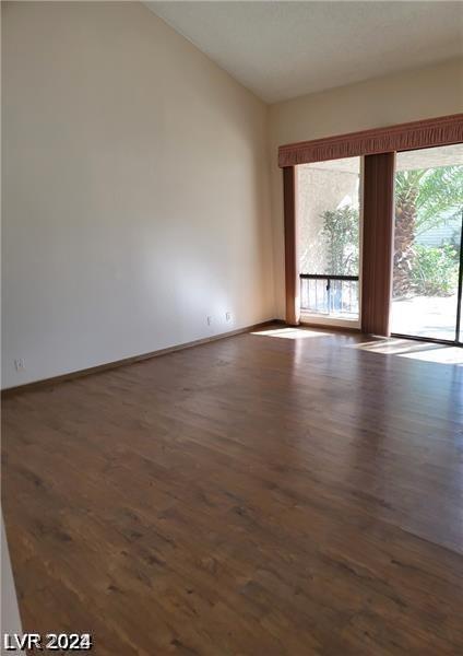 empty room featuring vaulted ceiling and hardwood / wood-style floors