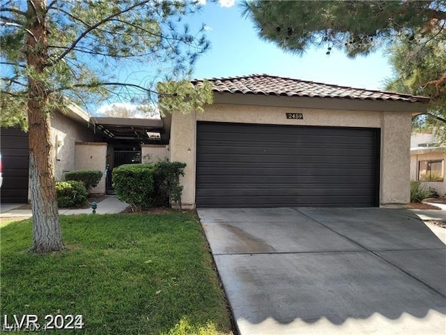 view of front of property featuring a garage and a front lawn