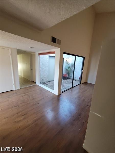 unfurnished room with a textured ceiling and hardwood / wood-style floors