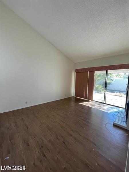 spare room with a textured ceiling and dark hardwood / wood-style floors