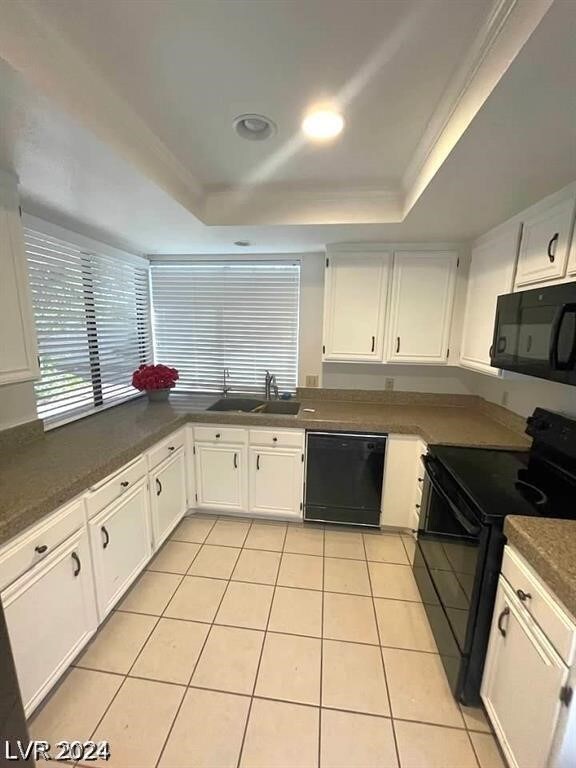 kitchen featuring white cabinets, black appliances, sink, and a tray ceiling