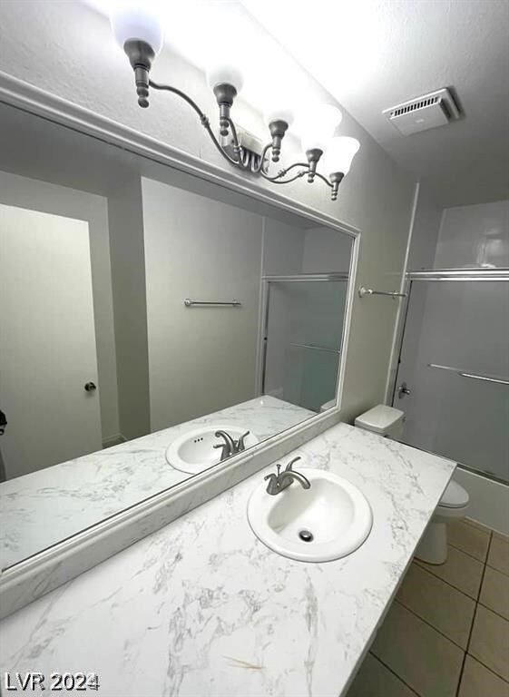 bathroom featuring vanity, toilet, and tile patterned flooring