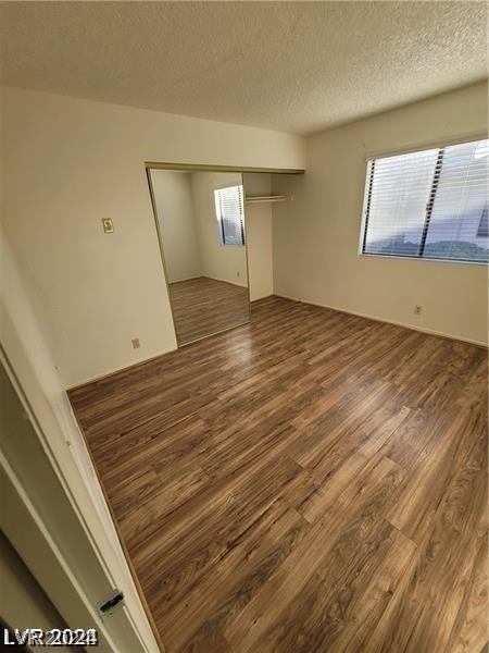 spare room featuring a textured ceiling and hardwood / wood-style flooring