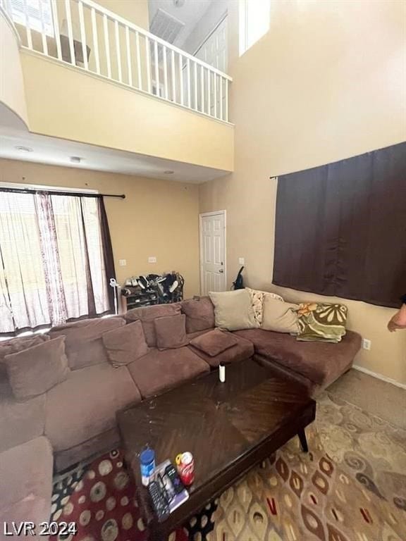 carpeted living room with a towering ceiling