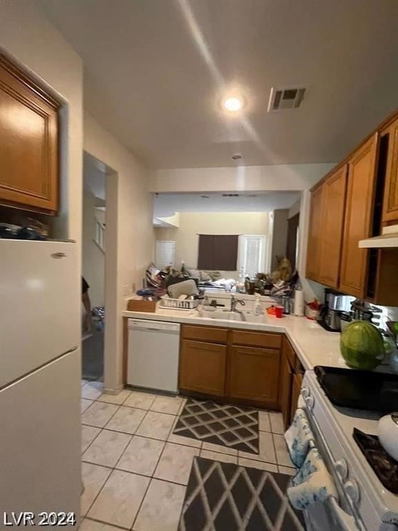 kitchen featuring sink, white appliances, and light tile patterned floors