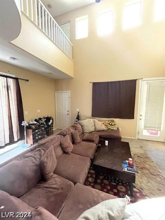 living room featuring carpet floors and a towering ceiling