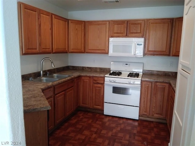 1501 Linnbaker Ln Unit 103, Las Vegas, NV 89110 - kitchen featuring white appliances, brown cabinetry, and dark countertops