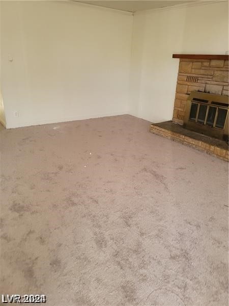 unfurnished living room featuring carpet flooring and a fireplace