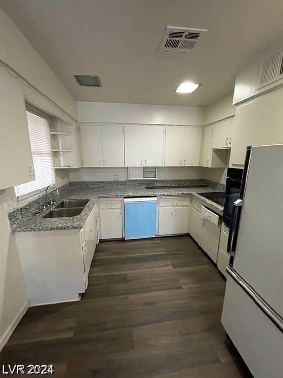 kitchen with white appliances, sink, dark hardwood / wood-style floors, stone countertops, and white cabinetry