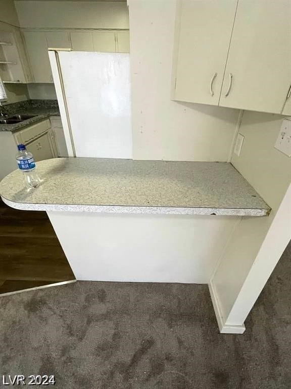 kitchen with white refrigerator, hardwood / wood-style floors, and sink