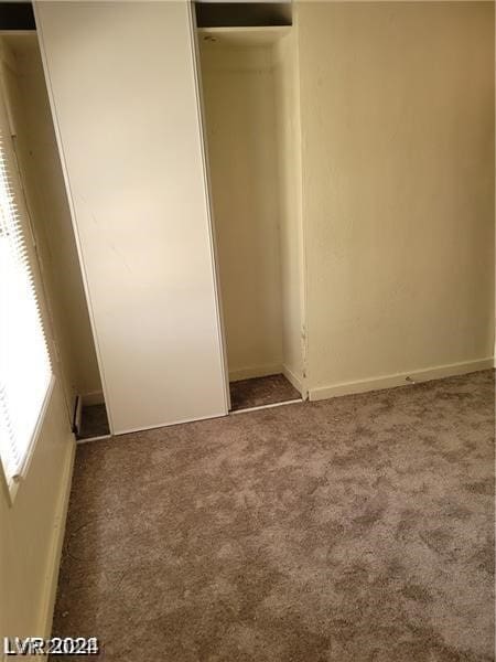 unfurnished bedroom with a closet and carpet flooring