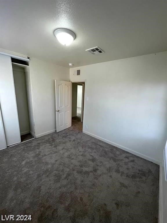 unfurnished bedroom featuring carpet and a closet