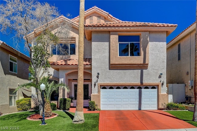 mediterranean / spanish house with a garage and a front lawn