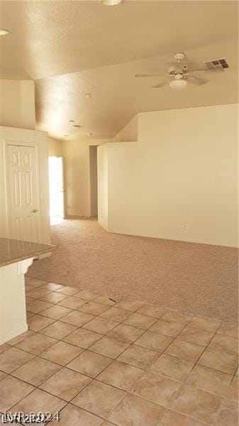 tiled empty room featuring ceiling fan