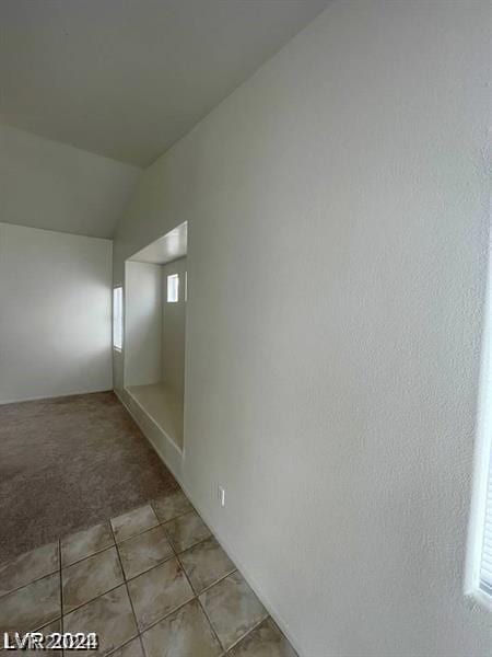 interior space featuring vaulted ceiling and light tile patterned floors