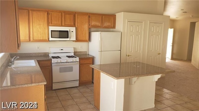 kitchen featuring a kitchen island, sink, light carpet, and white appliances