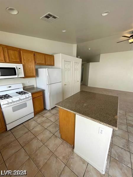 kitchen with ceiling fan, light tile patterned flooring, and white appliances