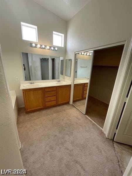 bathroom with vanity and high vaulted ceiling