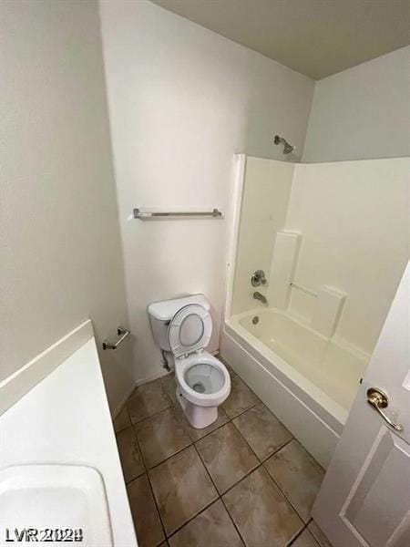 full bathroom featuring tile patterned floors, toilet, bathing tub / shower combination, and sink