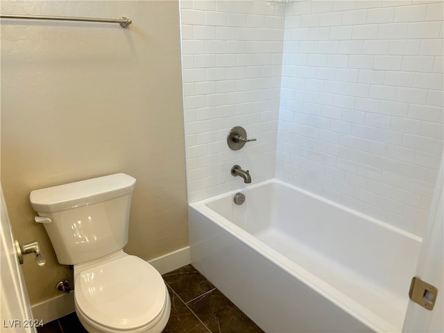 bathroom with tile patterned flooring, tiled shower / bath combo, and toilet